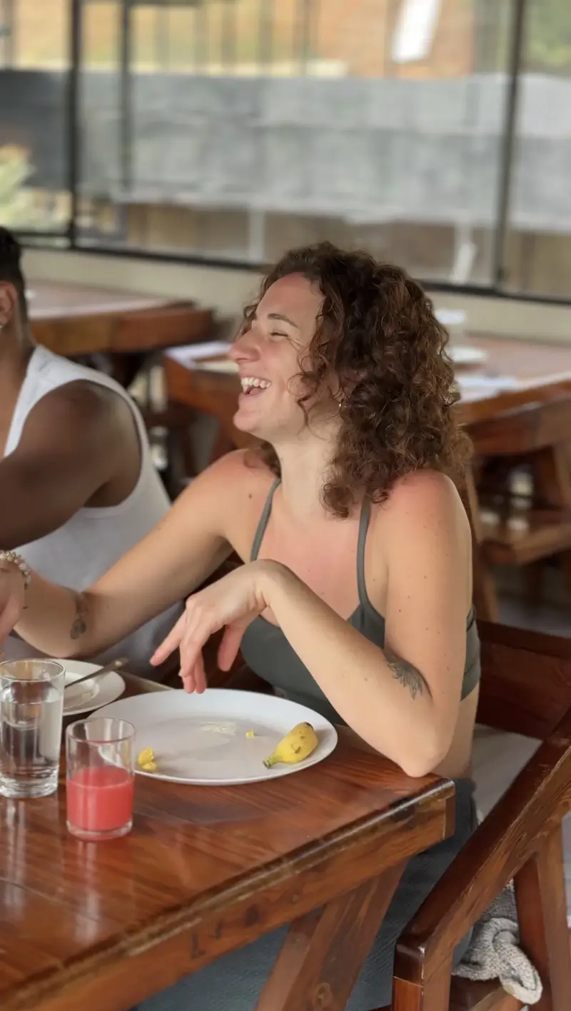 A student laughing at the table during a shared vegetarian meal